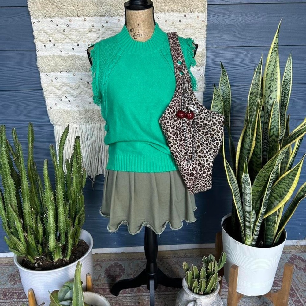 Soft, lightweight green sleeveless sweater vest with a fringe and braid details